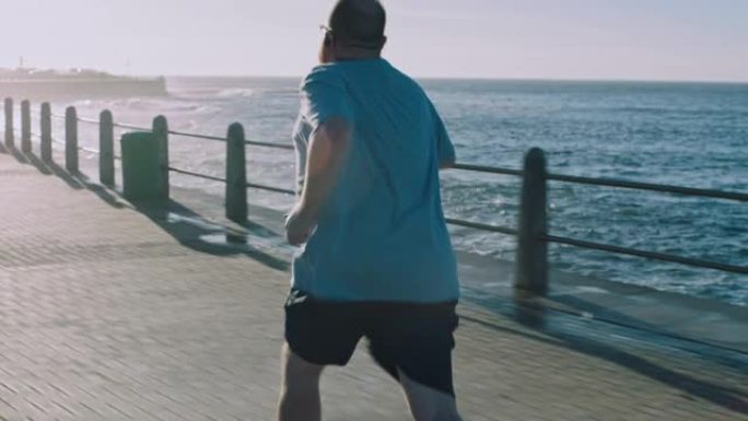 健身，加大码，男人在日出时沿着海滩跑步减肥，挑战和身体目标。运动，男人和跑步者专注于有氧运动，改变和