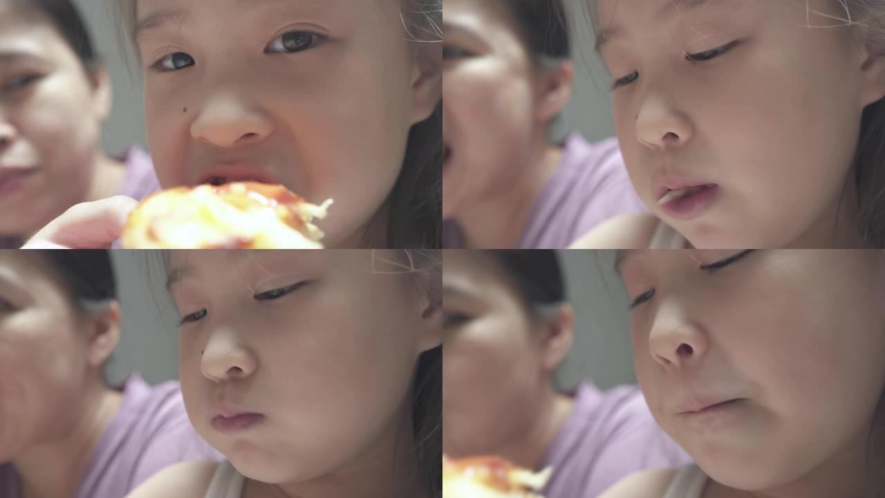 CU可爱的女孩和她的母亲喜欢在家吃披萨