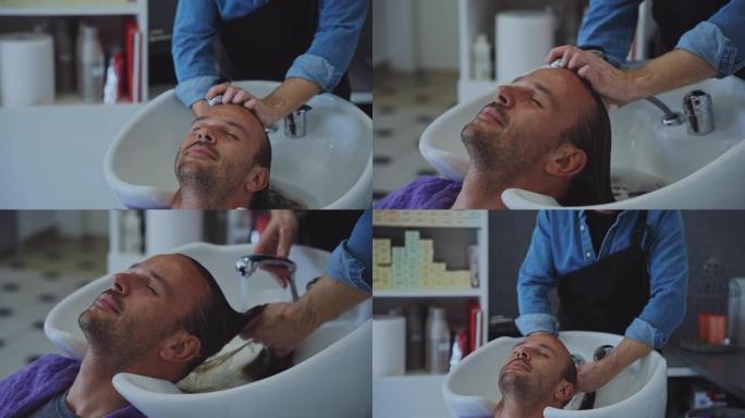 男性发型师在现代沙龙中洗头