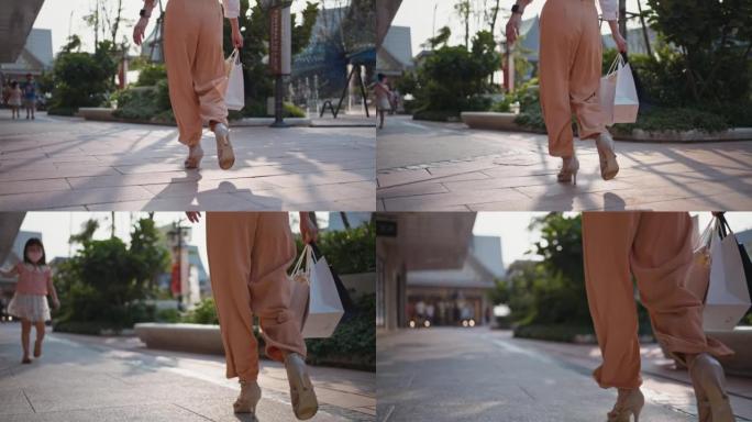 购物后拿着纸袋走在街上的女人