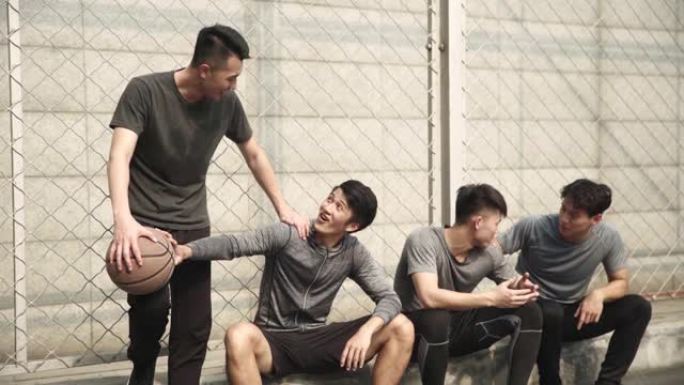亚洲年轻篮球运动员在球场边放松