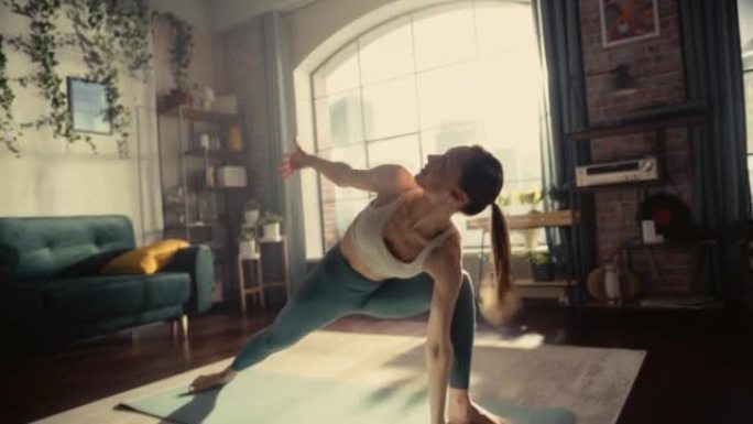 手持照片，一个年轻的运动女子早晨在她阳光明媚的家庭客厅锻炼，伸展和练习瑜伽。健康的生活方式、健身、幸