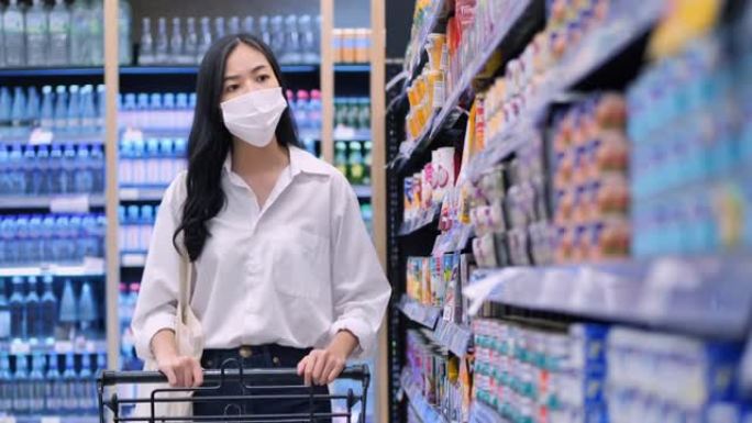 在新型冠状病毒肺炎冠状病毒流行期间，25岁的亚洲年轻女性戴着防护医用口罩在超市购买基本必需品。杂货店