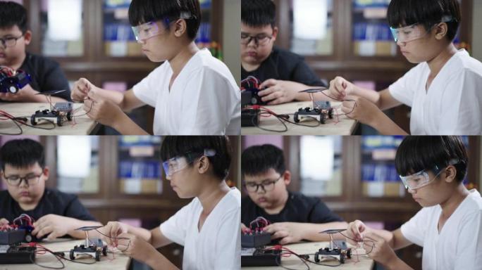 两个男孩建造和研究机器人STEM编程软件和固定