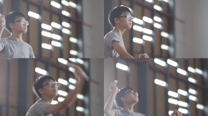 亚洲华裔少年少年在羽毛球场练习