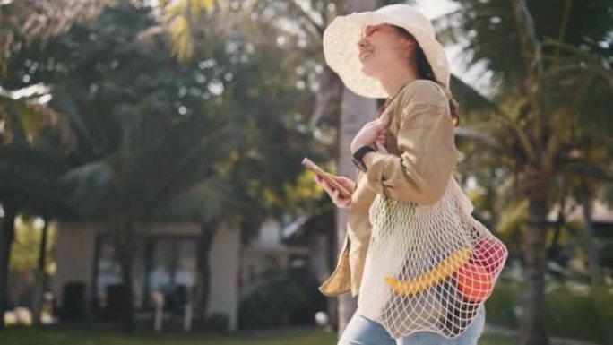 女人带着可重复使用的购物袋走到外面