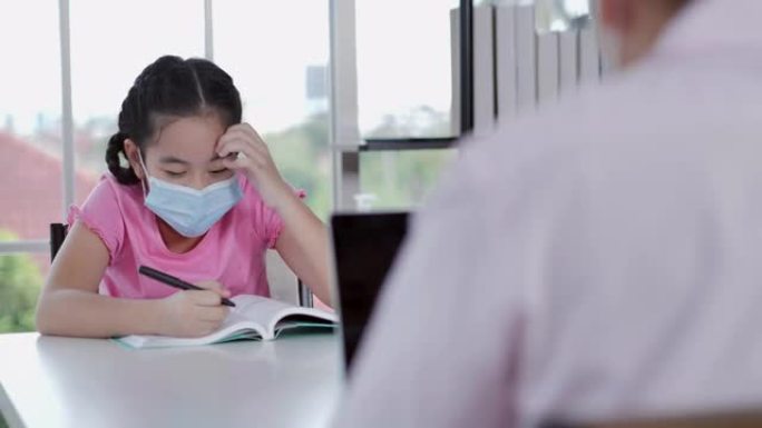 亚洲父亲的家庭，女儿11岁，在工作和在家上学的时候呆在家里，以防止冠状病毒或Covid-19.Hom