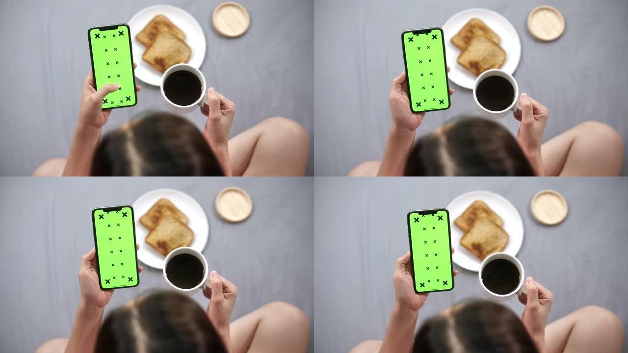 女人早上看着绿屏智能手机