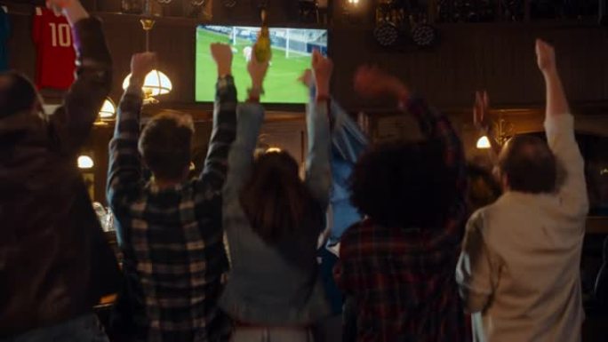 一群朋友在体育酒吧观看电视直播足球比赛。激动的球迷欢呼雀跃。年轻人庆祝球队进球并赢得世界杯足球赛。