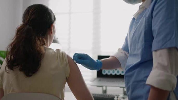 穿着防护服的女医生给病人注射疫苗，注射疫苗