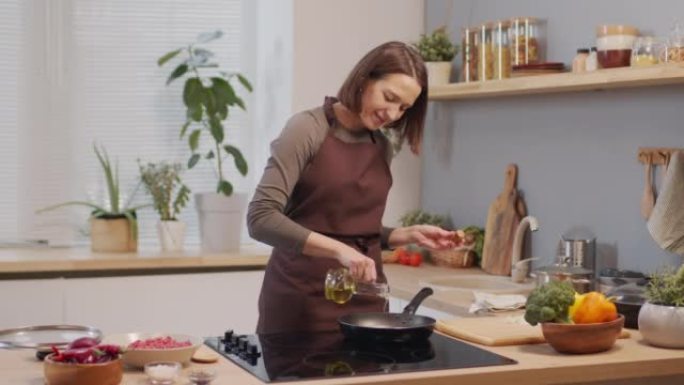 女人在做饭时在锅上倒油