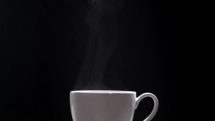 黑色背景上的热咖啡杯，特写