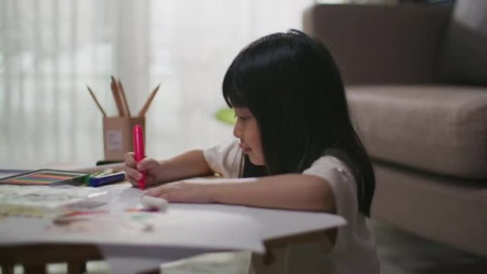 女孩在客厅的桌子上选择铅笔和做作业