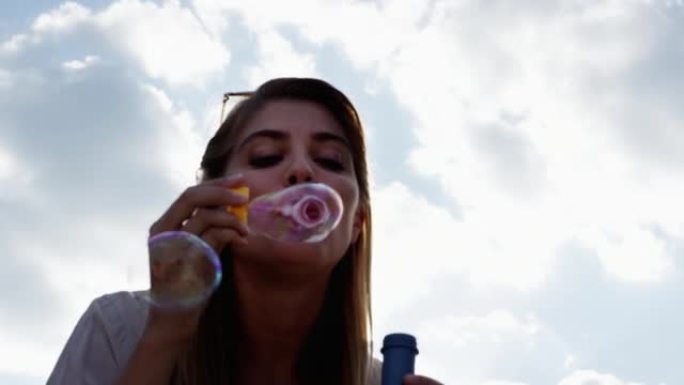 4k视频片段，一名妇女在外面吹泡泡