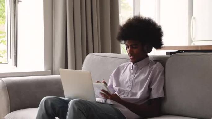 青少年非洲男子使用笔记本电脑和视频播放器应用程序在线学习