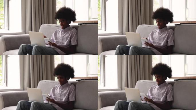 青少年非洲男子使用笔记本电脑和视频播放器应用程序在线学习