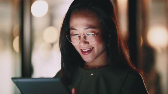 公司女性，带着微笑阅读平板电脑和夜晚，专注并为电子邮件交流，聊天或应用程序感到高兴。亚洲高管，社交媒