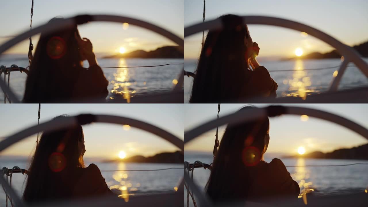 LS ZI孤独的女人坐在日落时航行的帆船甲板上