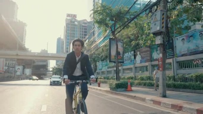 年轻的时髦男子在金融区骑自行车。