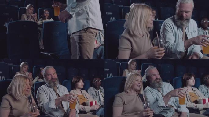 成熟的夫妇在电影院坐下