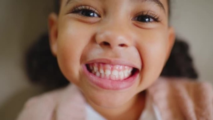 顽皮的小孩为正畸医生微笑，并对她的口腔卫生牙科预约充满信心。一个可爱的小女孩在牙医检查时露出牙齿的特