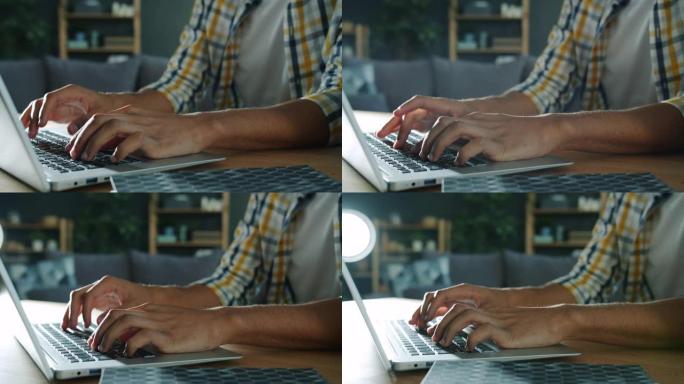男性双手打字的慢动作在家中与便携式计算机笔记本电脑一起工作