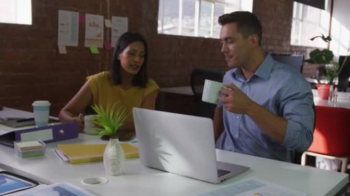 在工作中讨论的男女同事喝咖啡和微笑