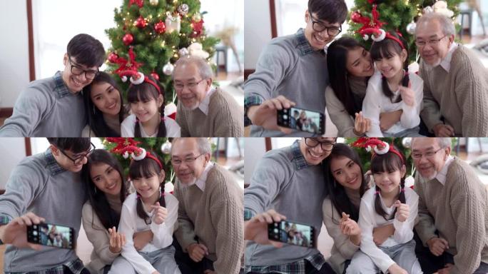 4K UHD倾斜多代亚洲幸福家庭在装饰完装饰品后与圣诞树一起自拍。