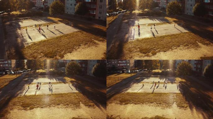 附近朋友在城市后院外面踢足球的空中无人机拍摄。多元文化的孩子们在郊区一起踢足球。快乐的童年和运动理念