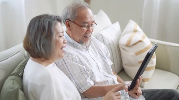 祖父母在家中的客厅数字平板电脑上给孙子的视频通话