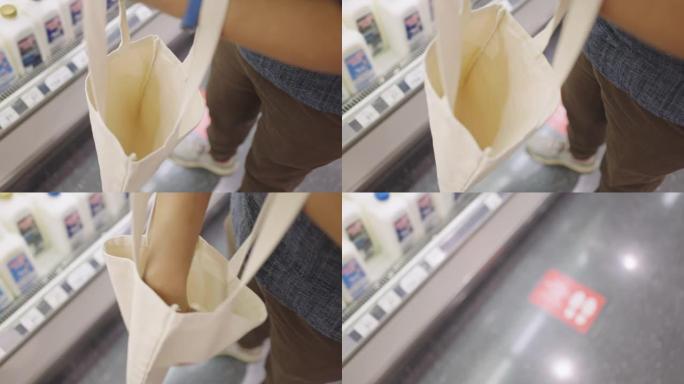 男子将半加仑牛奶放入布购物袋中