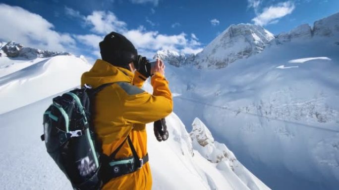 滑雪者在山顶上使用智能手机拍摄视频