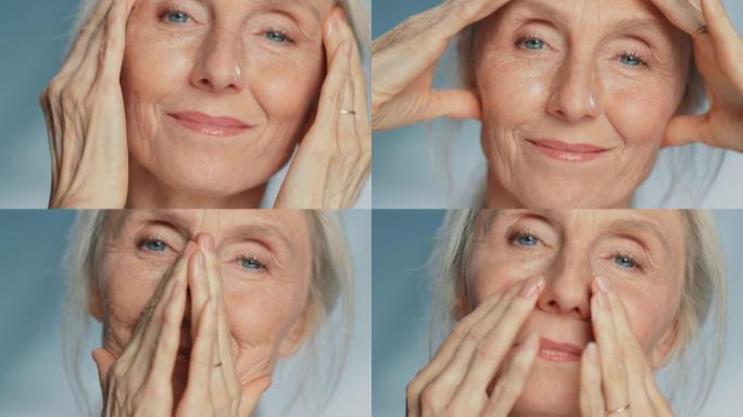 美丽的高级女人轻轻涂抹面霜的肖像。老年女士用天然抗衰老化妆品使皮肤柔软、光滑、无皱纹。美容护肤产品。