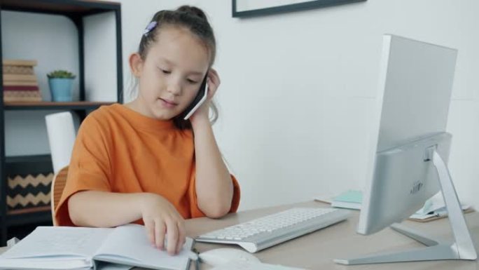 认真的小女孩用电脑做笔记，在家用手机聊天