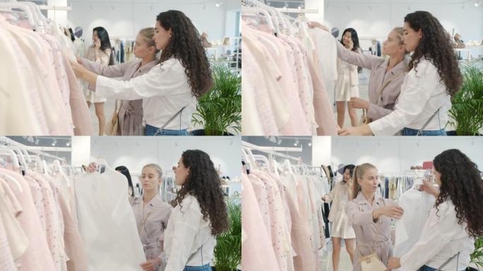 女性朋友在时装店选择时尚服装谈论和看衣架上的服装