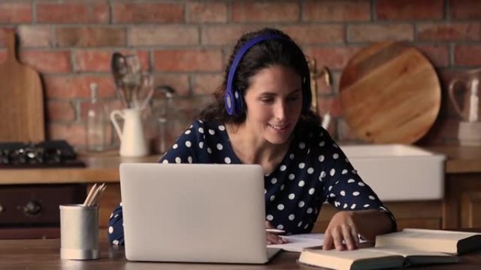 女人戴耳机跟在线老师学英语用笔记本电脑