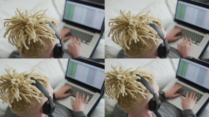 白化病非裔美国人使用平板电脑和耳机戴辫子