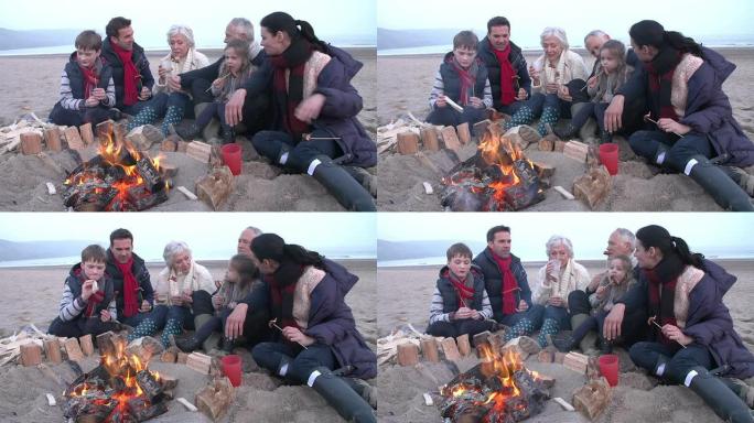 在冬季海滩上烧烤的多代家庭