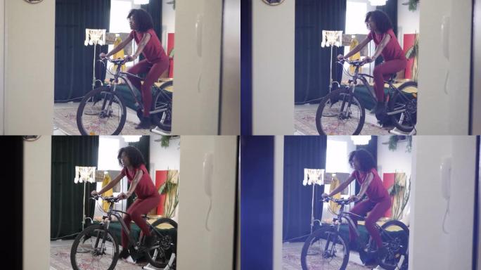 非裔美国女士正在家里骑自行车练习