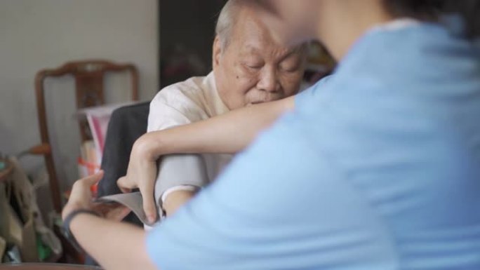 家庭护士试图给成年老人做血压测试