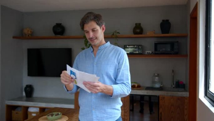 拉丁美洲男子在家中打开水电费账单，并收到邮件