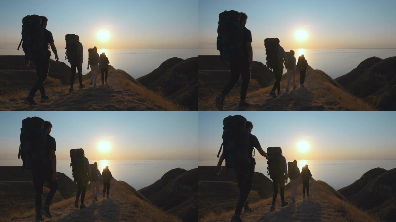 背着背包的游客在海边的山上行走。慢动作