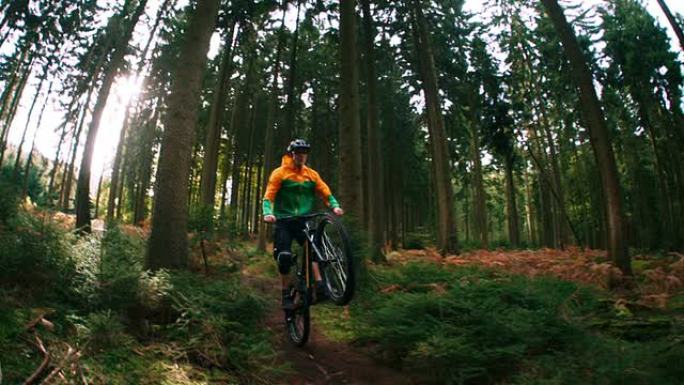 山地自行车手在树林中以慢动作骑在坡道上