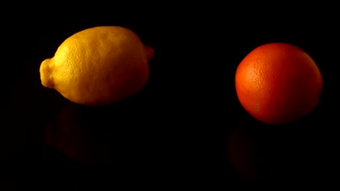 柠檬和橙色在黑色表面上旋转