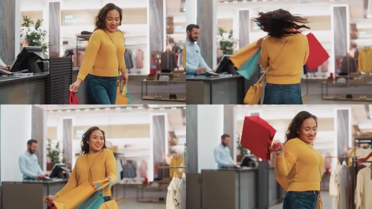 一个快乐的多民族女性带着购物袋在服装店微笑、跳舞和旋转的肖像。年轻的成年黑人女性顾客在百货商店购买时