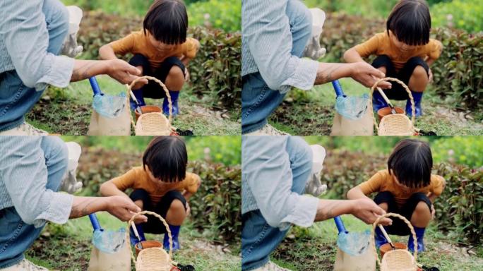 祖父在户外园艺教小男孩种豆。