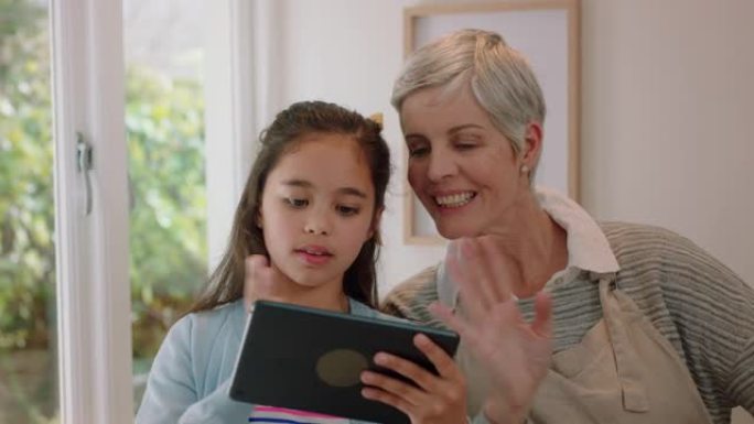 祖母和孩子使用平板电脑进行视频聊天小女孩与奶奶分享假期周末与孙女在家享受移动技术聊天