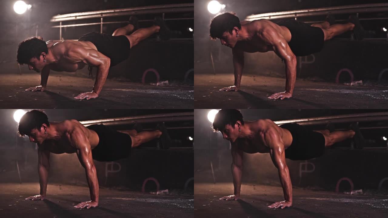 健康的亚洲运动男子运动员在废弃的黑暗健身房锻炼俯卧撑运动