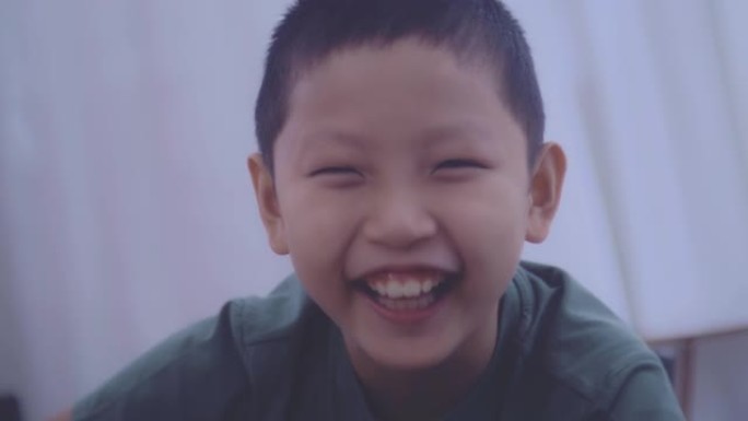 微笑的亚洲男孩早教幼儿园看绘画学习图书