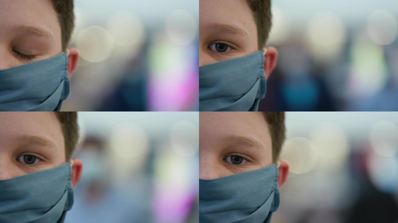 购物中心一名小男孩戴着防护口罩的特写裁剪肖像视图，以防止新型冠状病毒肺炎冠状病毒大流行
